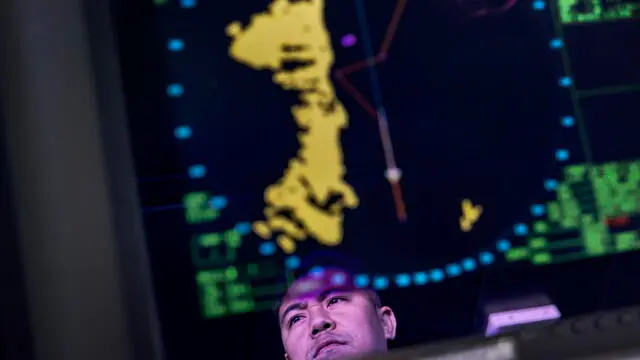 epa10719160 A navy personnel is reflected on a radar screen aboard Philippine Navy ship (BRP Tarlac) off the shore of Calayan Island Cagayan, Philippines. 30 June 2023. Philippines Armed Forces chief General Andres Centino conducted inspection of troops stationed in Muvalis island which lies at the country's northernmost tip near Taiwan. EPA/EZRA ACAYAN / POOL *** Local Caption *** BATANES, PHILIPPINES - JUNE 29: General Andres Centino, Chief of Staff of the Armed Forces of the Philippines, (3rd from left) takes part in a flag raising ceremony on June 29, 2023 in Mavulis Island, Batanes, Philippines. Amid increasing geopolitical tension between the US, China, and Taiwan, the Philippines is grappling with the potential fallout. Batanes, a group of idyllic islands at the countryâ€šÃ„Ã´s northernmost tip, lies just 140 kilometers from Taiwan, and its proximity could thrust it into the spotlight in case of conflict. Consequently, local officials and citizens are developing contingency plans to address security, food sufficiency, healthcare provisions, and the potential handling of refugees. (Photo by Ezra Acayan/Getty Images)