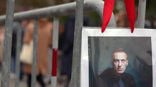 epa11226186 A portrait of Alexei Navalny is seen as Russians living in Switzerland gather in front of the Russian embassy in Bern to take their vote during the Russian presidential elections and simultaneously protest against President Putin in Bern, Switzerland, 17 March 2024. The Russian presidential election vote takes place between 15 and 17 March. Four candidates registered by the Central Election Commission of the Russian Federation are vying for the post of head of state: Leonid Slutsky, Nikolai Kharitonov, Vladislav Davankov and Vladimir Putin. The team of late Russian opposition leader Alexei Navalny had called Russians to show their opposition to the elections and President Putin, by crowding voting centers on 17 March at midday. The protest was named 'Noon Against Putin'. EPA/JULIEN GRINDAT