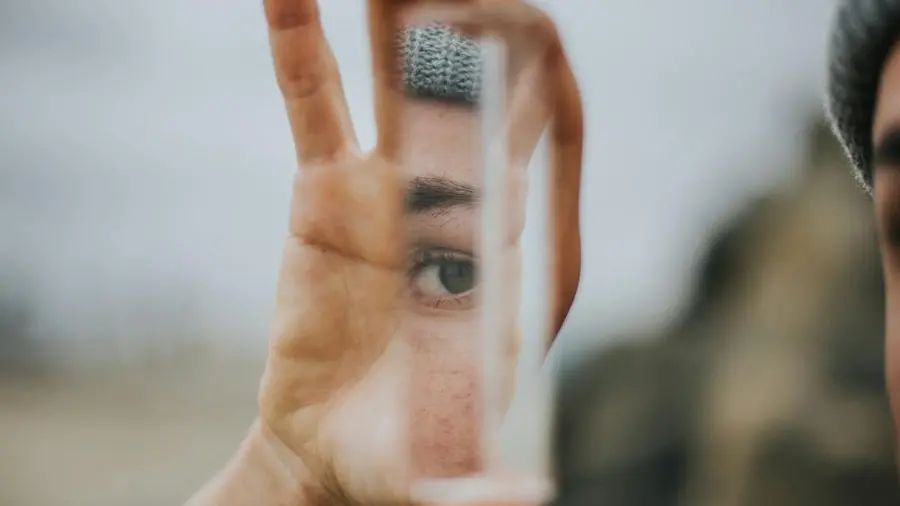 Una ragazza si guarda in uno specchio - Foto Unplash