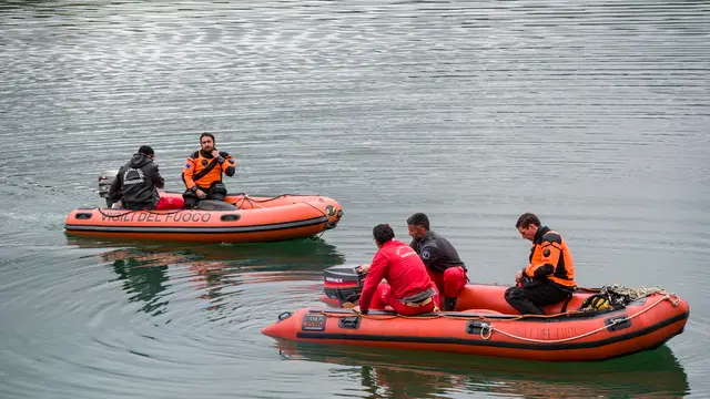 epa11269759 Rescuers on dinghies try to access the power plant on Lake Suviana during the search operations for those missing following an explosion, in Bargi, Italy, 10 April 2024. According to the Italian fire brigade (Corpo Nazionale dei Vigili del fuoco), at least three people died and four are missing after an explosion at the hydroelectric power plant in Bargi that took place on 09 April. EPA/MICHELE LAPINI