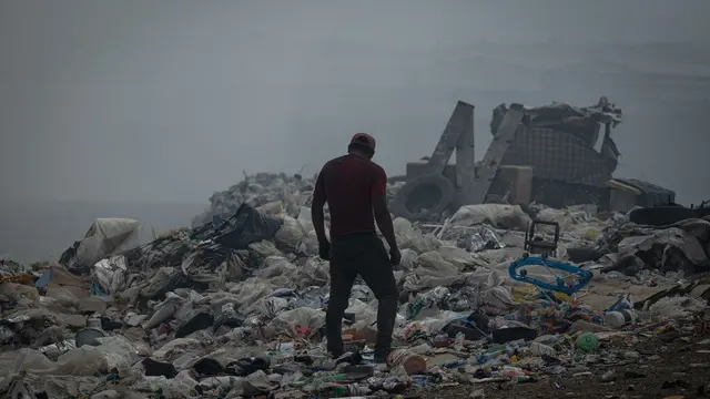 epaselect epa11271325 A man walks through a landfill area affected by the forest fires in Villa Nueva, Guatemala, 10 April 2024. The president of Guatemala, Bernardo Arevalo de Leon, issued a state of natural disaster declaration due to the forest fires that continue to burn across the Central American country. EPA/DAVID TORO