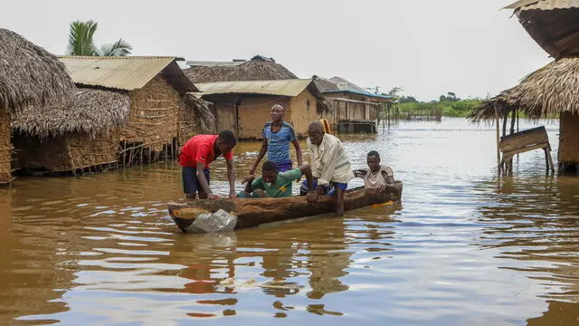 epa11015857 People use a dugout to move flood waters in Shirikisho village, Tana Delta region, in Kenya, 07 December 2023. The death tool due to rainfalls and floods in Kenya has surged to 160 and displaced more than 500,000 people according to the government. Since November 2023, Kenya, Somalia and Ethiopia have been affected by downpours linked to the El Nino phenomenon. EPA/ANDREW KASUKU