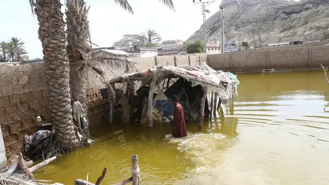 epa11201646 A person affected by torrential rains wades in water in Gwadar, Pakistan, 06 March 2024. Gwadar, a port city in southwestern Balochistan province, has been declared a calamity-hit area after enduring two days of relentless torrential rains. The announcement was made by Balochistan's caretaker Information Minister, Jan Achakzai, citing the distressing situation caused by the severe weather conditions. EPA/REHAN KHAN