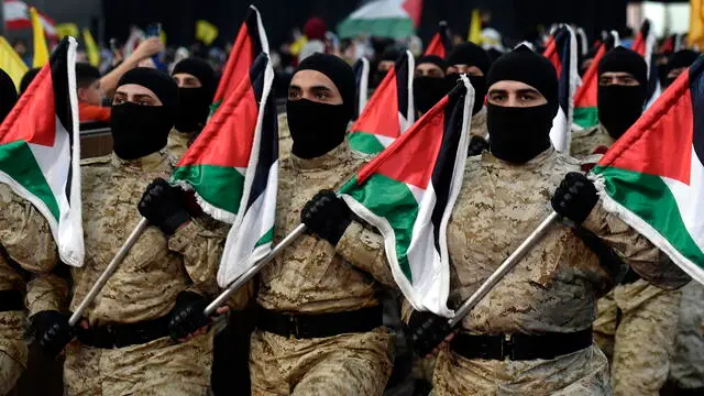 epa11260698 Hezbollah members parade as they carry Palestinian flags during a gathering to commemorate Al Quds Day (Jerusalem Day) in a suburb of Beirut, Lebanon, 05 April 2024. Al Quds Day was declared in 1979 by the late Ayatollah Khomeini, founder of the Islamic Iranian Republic, who called on the world's Muslims to show solidarity with Palestinians on the last Friday of the fasting month of Ramadan. EPA/WAEL HAMZEH