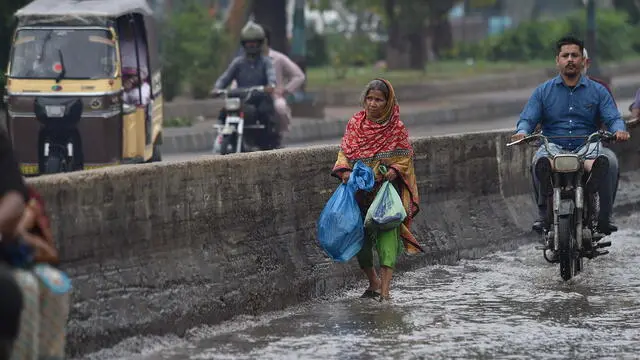 epa11278195 People make their way during heavy rain in Karachi, Pakistan, 14 April 2024. At least 29 people have died and another seven have been injured in the last two days due to lightning strikes and incidents related to the heavy rains affecting several provinces of Pakistan, rescue officials said. In total, 17 people died in the northeastern province of Punjab, in addition to eight deaths in southern Balochistan and four in northern Khyber Pakhtunkhwa. EPA/SHAHZAIB AKBER