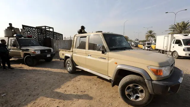 epa11056973 Members of Iraqi Shiite Popular Mobilization Forces (PMF) near a gate after a reported drone attack on a security headquarters in Baghdad, Iraq, 04 January 2024. Major General Yahya Rasul, the Spokesperson for the Iraqi Commander-in-Chief of the Armed Forces in a statement posted on X (formerly Twitter) said that a drone targeted a security headquarters in the capital Baghdad on 04 January, resulting in casualties. The statement continued saying that the Iraqi Armed Forces 'hold the Global Coalition Forces responsible for this unwarranted attack on an Iraqi security entity', adding that the event was seen as a 'dangerous escalation and assault on Iraq'. EPA/AHMED JALIL