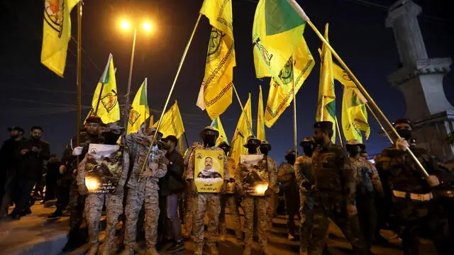 epaselect epa11057524 Members of Iraqi Shiite Popular Mobilization Forces (PMF) carry their flag during the funeral of their leader Abu Taqwa Al-sia'di, who was killed in a US drone attack in Baghdad, Iraq, 04 January 2024. A US drone strike on January 4, targeted an Iranian-backed Popular Mobilization Forces base in eastern Baghdad, killing two commanders and wounding six others from the Popular Mobilization Forces' 12th Brigade, PMF announced to the media. EPA/AHMED JALIL