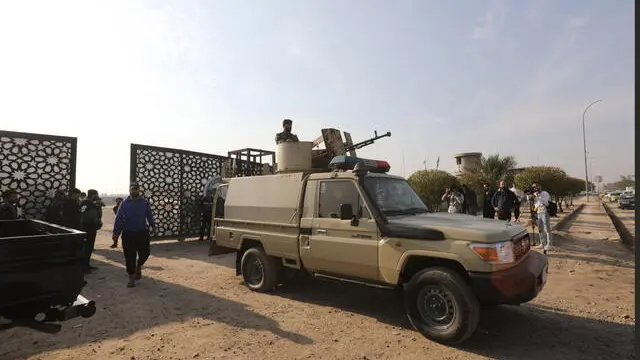 epaselect epa11056976 Members of Iraqi Shiite Popular Mobilization Forces (PMF) near a gate after a reported drone attack on a security headquarters in Baghdad, Iraq, 04 January 2024. Major General Yahya Rasul, the Spokesperson for the Iraqi Commander-in-Chief of the Armed Forces in a statement posted on X (formerly Twitter) said that a drone targeted a security headquarters in the capital Baghdad on 04 January, resulting in casualties. The statement continued saying that the Iraqi Armed Forces 'hold the Global Coalition Forces responsible for this unwarranted attack on an Iraqi security entity', adding that the event was seen as a 'dangerous escalation and assault on Iraq'. EPA/AHMED JALIL