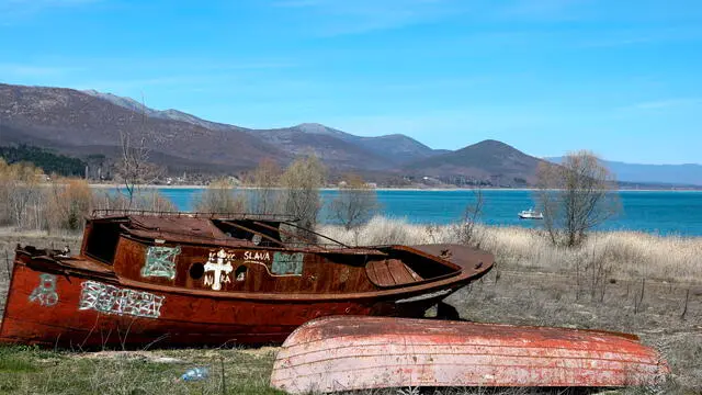 epa11233935 Abandoned boats sit on dry land after the water level of the Prespa Lake dropped and the shore retracted hundreds of meters, in the village of Stenje, near Resen, Republic of North Macedonia, 21 March 2024. Lake Prespa, located on the borders of Albania, Greece and North Macedonia, falls in the category of ancient lakes, and it is older than 130 000 years. According to the professor of the Technical Faculty in Bitola, Dejan Trajkovski, the lake's water level reduces by 19 centimeters per year and according to NASA, in the past 60 years, Prespa has lost some 40 percent of its volume of water. If the trend continues, at this rate, helped by global warming and pumping, it most certainly will only accelerate, and in about 60 to 80 years most of the bottom of the lake will remain dry, similar fate as Kazakhstan's Aral Sea. North Macedonia's Directorate for Hydrometeorological Affairs (HMRC) has measured, on the North Macedonian side of the lake, a 9,93m lower value than considered normal for the lake. Divided by only 10 km from another ancient lake, Ohrid, the two lakes share a tight bond. Since Prespa is located on the higher ground, much of the water in the Ohrid lake is drawn from Prespa, showing potential of lowering the water level of Ohrid lake as well. EPA/GEORGI LICOVSKI