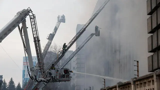 epa11231883 Ukrainian firefighters work to extinguish a fire at the site of a rocket attack on an industrial building in the Kholodnohirskyi district of Kharkiv, northeastern Ukraine, 20 March 2024, amid the Russian invasion. At least five people were killed and at least 6 others were injured after a Russian missile strike hit one of the districts of Kharkiv, the State Emergency Service of Ukraine said. The regional military administration reported that a number of people could be trapped under the rubble. EPA/SERGEY KOZLOV