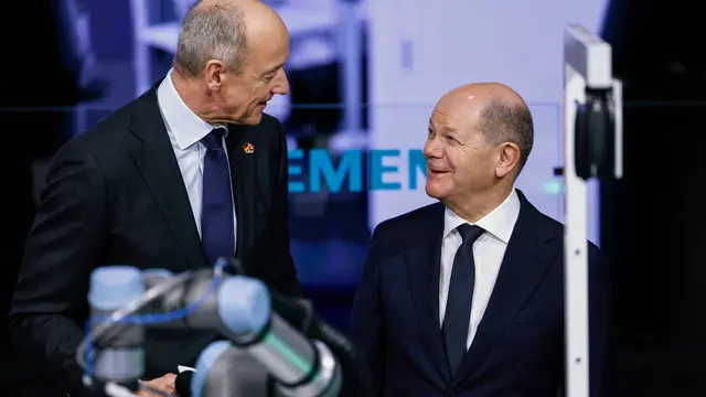 epa11293527 German Chancellor Olaf Scholz (L) talks to Roland Busch (L), Chairman of the Managing Board, President & CEO of Siemens AG, as he attends the opening tour at the annual industry trade fair 'Hannover Messe', in Hanover, Germany, 22 April 2024. Around 4000 exhibitors from the mechanical engineering, electrical and digital industries as well as the energy sector will showcase their latest technologies, developments and solutions at the fair from 22 to 26 April 2024. The fair will focus on climate protection, sustainability and artificial intelligence. EPA/HANNIBAL HANSCHKE