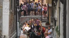 Gondole e turisti su un canale interno del centro storico oggi 13 agosto 2022. ANSA/ANDREA MEROLA