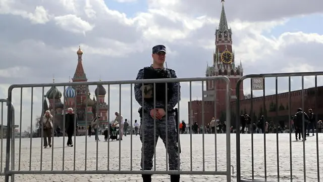 epa11256910 A Russian policeman stands guard at the Red Square outside the Kremlin during spring weather in Moscow, Russia, 03 April 2024. The temperatures have reached fourteen degrees Celsius in the Russian capital. EPA/MAXIM SHIPENKOV