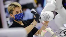 epa10127102 An exhibitor staff tests on the performance of a surgery robot during the 2022 World Robot Conference (WRC) at Yichuang International Convention and Exhibition Center in Beijing, China, 18 August 2022. The 2022 WRC is held from 18 to 21 August and includes a conference on robotics, an exhibition and a robot competition with the participation of more than 130 robotics enterprises from 15 countries and regions that showcase more than 500 robot products. EPA/WU HAO
