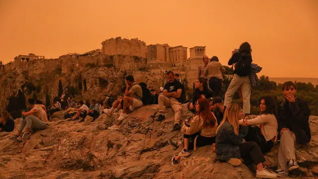 epa11296330 People stroll around the Acropolis area while African dust covers the sky of Athens, Greece, 23 April 2024. According to the National Observatory of Athens, the atmospheric circulation over Greece favors the transfer of warm air masses from Africa to Greece, resulting in very high temperatures and the transfer of significant amounts of Saharan dust. EPA/GEORGE VITSARAS