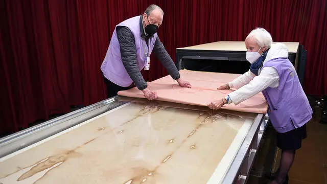 In a handout photo made available by the diocese of Turin, the Holy Shroud, the 14 foot-long linen revered by some as the burial cloth of Jesus is seen been prepared for for a special liturgy on Holy Saturday held at the Turin's Cathedral, Turin, Italy, 3 april 2021. ANSA +++ ++ HO - NO SALES, EDITORIAL USE ONLY ++