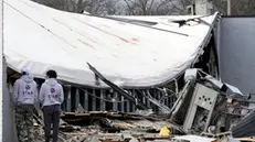 epa11022200 People look over at a damaged business after an apparent tornado struck in Hendersonville, Tennessee, USA, 10 December 2023. At least six people were killed after suspected tornados and severe weather swept through portions of middle Tennessee on 09 December 2023, according to authorities. EPA/MARK HUMPHREY