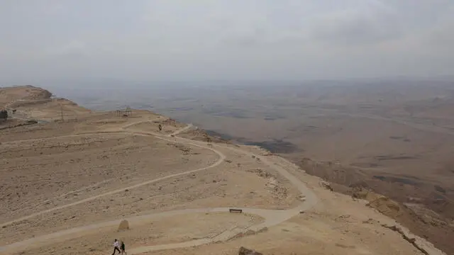 epa10895646 People walk at the observation point of Ramon Crater near the Israeli town of Mitzpe Ramon in southern Israel, 02 October 2023. The site is one of the attractions for hikers in Israel. The 40-km long Ramon crater is the worldâ€™s largest erosion crater (makhtesh) which is a unique landform in Israel's Negev and Egypt's Sinai deserts that was created some 220 million years ago when oceans covered the area, TouristIsrael and the Israel Nature and Parks Authority describe the geological phenomenon on their websites. EPA/ABIR SULTAN