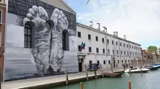 epa11291934 The work 'Father' by Italian artist Maurizio Cattelan, depicting two bare feet, is on display on the outer wall of the Church of Santa Maria Maddalena delle Convertite in Venice, Italy, 21 April 2024. The work is part of the Pavilion of the Holy See for the 60th international art exhibition La Biennale di Venezia, which runs from 20 April to 24 November 2024. EPA/ANDREA MEROLA