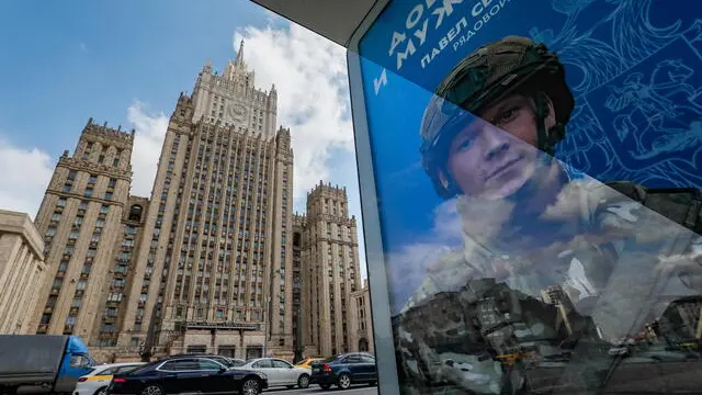 epa11293899 Cars drives past a billboard advertising military conscription in front of the main building of the Russian Ministry of Foreign Affairs, in Moscow, Russia, 22 April 2024. According to Russian Defence Minister Sergei Shoigu, almost 540 thousand people entered military service under contract in the Russian Armed Forces in 2023, and about 50 thousand since the beginning of 2024. EPA/YURI KOCHETKOV