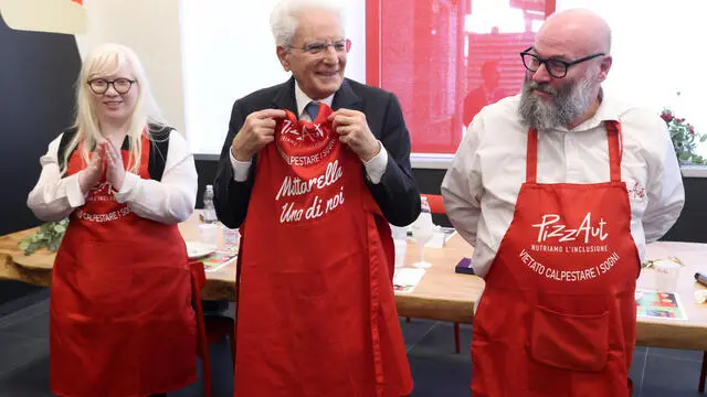 Il presidente della Repubblica Sergio Mattarella (C) con Nico Acampora (D) in occasione della cerimonia di inaugurazione del secondo locale di PizzaAut la pizzeria interamente gestita da ragazzi autistici. Monza 2 Aprile 2023. ANSA / MATTEO BAZZI