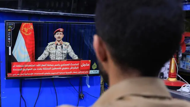 epa11229586 A person watches Houthi military spokesman Yahya Sarea delivering a TV statement over new shipping attacks, in Sana'a, Yemen, 19 March 2024. Yemen's Houthis have launched new missile attacks against a tanker, MADO, in the Red Sea, and Israel's Eliat region, which borders the Red Sea, according to a TV statement by Houthi military spokesman Yahya Sarea. The US-led coalition continues to strike Houthi targets in Yemen as it seeks to degrade the Houthis' abilities to attack commercial shipping vessels in the Red Sea and the Gulf of Aden amid high tensions in the Middle East. In light of increased maritime security threats, the US has designated the Houthis as a 'Specially Designated Global Terrorist Group'. EPA/YAHYA ARHAB