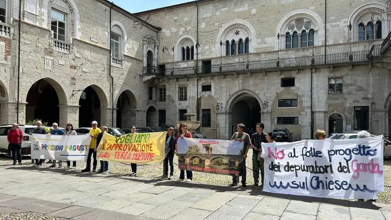 Gli attivisti del presidio 9 agosto nel cortile del Broletto -  © www.giornaledibrescia.it