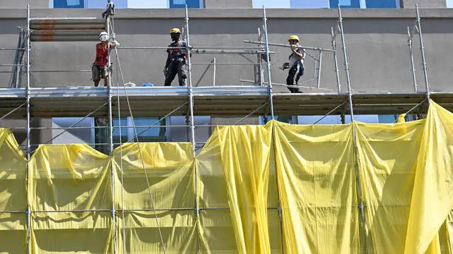 Operai edili al lavoro sulla facciata di uno stabile di Milano, 6 settembre 2023. ANSA/DANIEL DAL ZENNARO