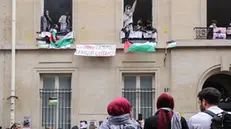 epaselect epa11303015 Students who occupied the Institut d'etudes politiques (Sciences Po Paris) display a banner reading 'We ask for justice, we get the police' during a demonstration to support the Palestinian people in Paris, France, 26 April 2024. A dozen students remain mobilized in support of the Palestinians by occupying a building at Sciences Po Paris since the evening of 25 April 2024, the day after police evacuated another of the school's sites, following actions taken at several universities in the United States in support of the Palestinian people. EPA/TERESA SUAREZ