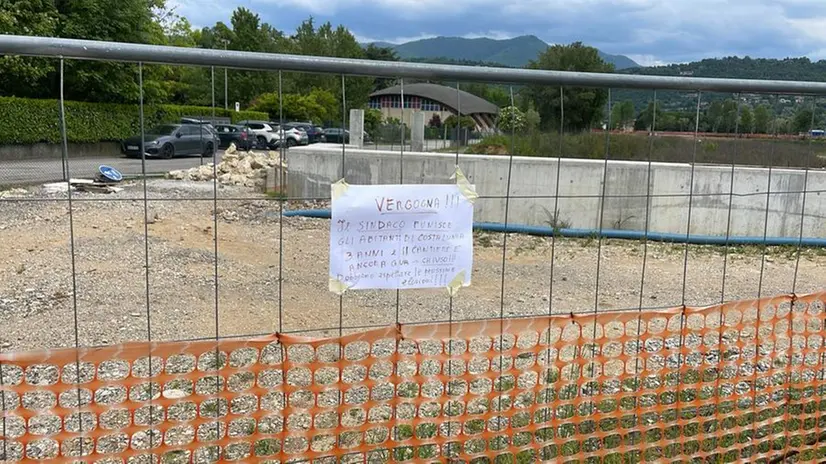 Il cartello di protesta sulla rete del cantiere in via Garzetta - Foto © www.giornaledibrescia.it