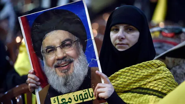 epa11260746 A Hezbollah supporter holds up a picture of Hezbollah leader Hassan Nasrallah during a gathering to commemorate Al Quds Day (Jerusalem Day) in a suburb of Beirut, Lebanon, 05 April 2024. Al Quds Day was declared in 1979 by the late Ayatollah Khomeini, founder of the Islamic Iranian Republic, who called on the world's Muslims to show solidarity with Palestinians on the last Friday of the fasting month of Ramadan. EPA/WAEL HAMZEH