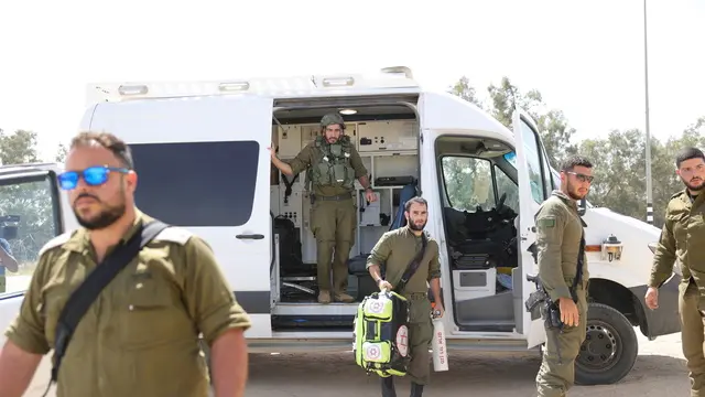 epa11319517 Israeli soldiers and paramedics gather near the Kerem Shalom crossing, at the border with the Gaza Strip ,southern Israel, 05 May 2024. According to the Israel Defense Forces (IDF), approximately 10 projectile launches were identified crossing from the area adjacent to the Rafah Crossing toward the area of Kerem Shalom on 05 May. The Kerem Shalom crossing is currently closed to the passage of humanitarian aid trucks, the IDF added. EPA/ABIR SULTAN