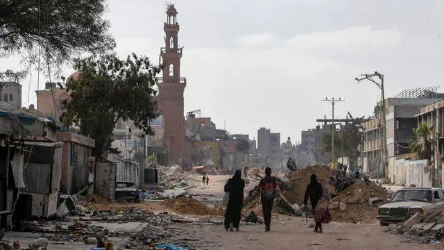 epa11310559 Palestinians walk among destroyed buildings as they return to Khan Younis after the Israeli military pulled out troops from the southern Gaza Strip, 30 April 2024. According to the United Nations, it will take years to clear the around 23 millions tonnes of rubble and unexploded weapons currently scattered across the Gaza Strip. EPA/MOHAMMED SABER
