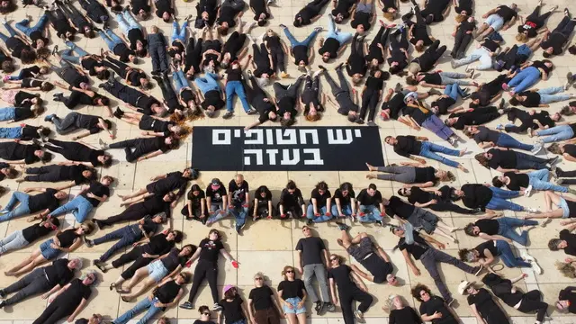 epaselect epa11295111 Families of Israeli hostages held by Hamas in Gaza and their supporters lie on the ground with their hands painted in red near a sign reading 'There are hostages in Gaza' (C) during a protest performance to mark 200 days since the 07 October abductions and attack, in Habima square in Tel Aviv, Israel, 23 April 2024. According to the Israeli military, 133 Israelis, who were abducted and taken to the Gaza Strip during the 07 October 2023 attacks by Hamas, remain in captivity. Rallies in Israel have been critical of the government's handling of the crisis, demanding the immediate release of all hostages. EPA/ABIR SULTAN