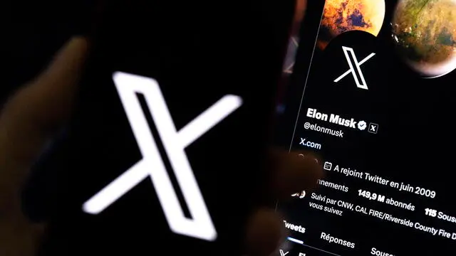 epa10772438 An illustration pictures shows a user holding a mobile phone displaying the 'X' logo in front of Elon Musk's page in Los Angeles, California, USA, 27 July 2023. Twitter announced on 23 July that it will rebrand to X. EPA/ETIENNE LAURENT