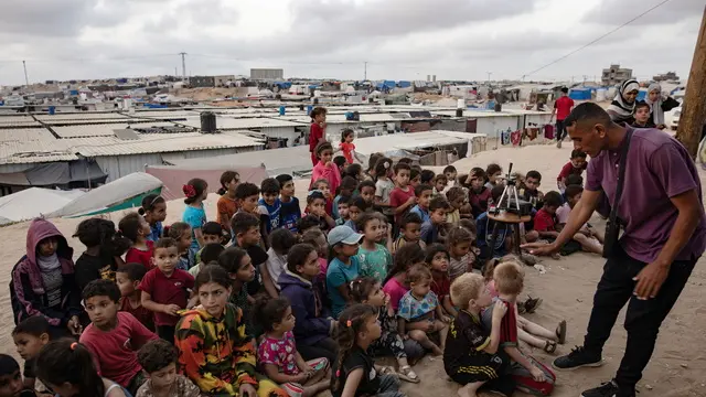 epa11307410 Children gather at a makeshift cinema set up among the tents of the Rafah refugee camp, southern Gaza Strip, 28 April 2024. The cinema was set up by internally displaced Palestinian Muhammad Al-Khudari to entertain children with cartoons. Since 07 October 2023, up to 1.9 million people, or more than 85 percent of the population, have been displaced throughout the Gaza Strip, some more than once, according to the United Nations Relief and Works Agency for Palestine Refugees in the Near East (UNRWA), which added that most civilians in Gaza are in 'desperate need of humanitarian assistance and protection'. EPA/HAITHAM IMAD