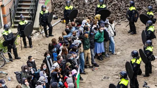 epa11327689 Protesters are surrounded by police at a University of Amsterdam (UvA) building on the Binnengasthuis grounds, Amsterdam, Netherlands, 08 May 2024. Entrances to the site were blocked from several sides with, among other things, pallets and bicycle racks. The demonstrators were protesting in solidarity with pro-Palestinian students who were removed by police during protests at the Roeterseiland campus. EPA/RAMON VAN FLYMEN
