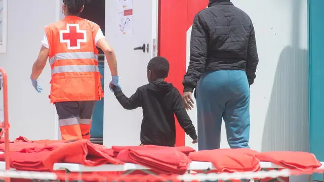 epa11329546 A Red Cross staff assists rescued migrants at the port of Gran Tarajal, slas Canarias, Spain, 09 May 2024. Maritime Rescue has rescued 112 migrants of sub-Saharan origin who were trying to reach Fuerteventura in two inflatable boats, including three women and a child. EPA/Carlos de Saa