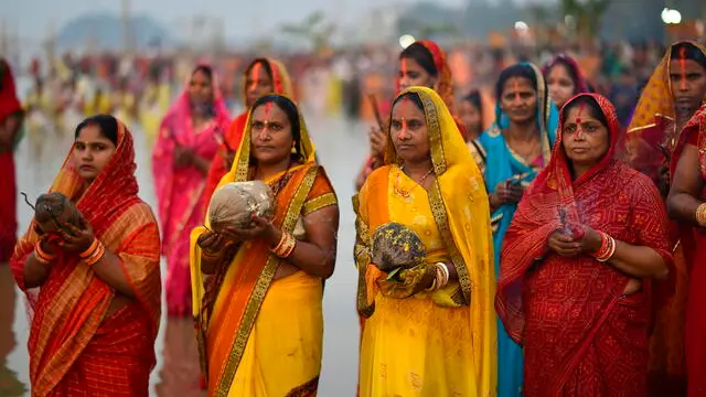 epa08831379 Indian Hindu devotees perform rituals as they worship the setting Sun while celebrating Chhath Puja festival at the bank of the Brahmaputra River in Guwahati, Assam India, 20 November 2020. Chhath Puja is a worship of the setting and rising Sun and is dedicated to Chhatti Mai, the goddess of power. The festival is seen as a serene event when bejewelled women in colourful saris visit the banks of rivers and ponds, singing folk songs and take a dip in the water and pray to the Sun god. EPA/STR