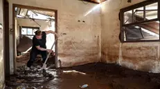 epaselect epa11327663 Brazilian Maria Olbermann, 65, cleans her house after the Taquari river overflowed its banks in Cruzeiro do Sul, Rio Grande do Sul state, Brazil, 08 May 2024. The death toll from catastrophic floods in southern Brazil has exceeded 100, according to the latest figures released by the Civil Defense on 08 May. EPA/SEBASTIAO MOREIRA