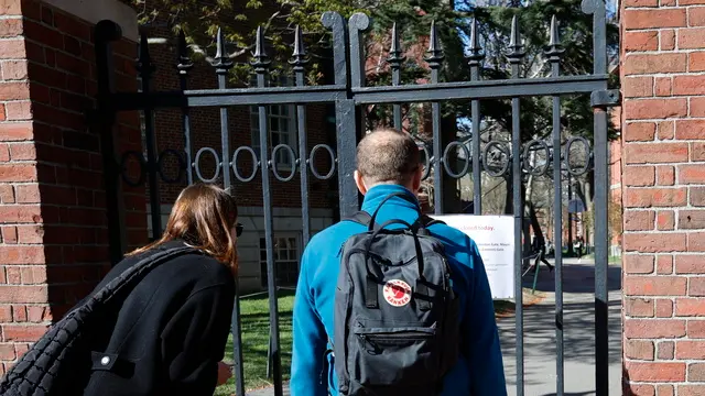 epa11294861 Passers-by stop to read a sign stating 'Harvard Yard Will Be Closed Today,' affixed to McKean Gate leading into Harvard Yard, in a effort to curb protest of Israel on the campus, in Cambridge, Massachusetts, USA, 22 April 2024. Students at Massachusetts Institute of Technology and Emerson College set up 'tent cities,' as a protest of the schools ties to Israel and state they will protest until the administrations cuts financial ties to Israel. More than 34,000 Palestinians and over 1,450 Israelis have been killed, according to the Palestinian Health Ministry and the Israel Defense Forces (IDF), since Hamas militants launched an attack against Israel from the Gaza Strip on 07 October 2023, and the Israeli operations in Gaza and the West Bank which followed it. EPA/CJ GUNTHER