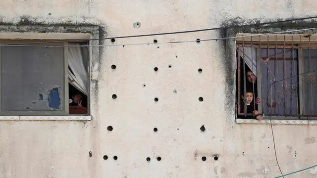 epa11234113 Palestinians look out of the windows of their damaged home following an Israeli raid at Nur Shams camp, near the West Bank city of Tulkarem, 21 March 2024. According to the Palestinian Ministry of Health, at least four Palestinians were killed in clashes during an Israeli operation at Nur Shams camp. EPA/ALAA BADARNEH