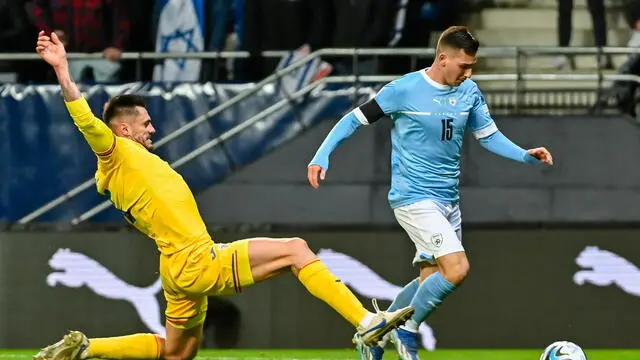 epa10983529 Israel’s Oszkar Glouh (R) in action against Romania's Andrei Burca during the UEFA EURO 2024 Group I qualifying soccer match between Israel and Romania in Felcsut, Hungary, 18 November 2023. EPA/Tamas Vasvari HUNGARY OUT