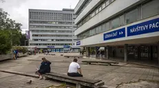 epa11346980 People sit outside the F. D. Roosevelt University Hospital, where Slovak Prime Minister Robert Fico is being treated after being shot two days earlier, in Banska Bystrica, Slovakia, 17 May 2024. The Slovak government office on 15 May confirmed there had been an assassination attempt on Prime Minister Robert Fico following a meeting in the town of Handlova. Slovak President-elect Peter Pellegrini, who visited Fico in hospital and spoke with him, told journalists that Fico's condition remains very serious. EPA/MARTIN DIVISEK