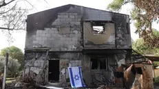 epa11038555 An Israeli flag is placed on a burnt-out house in Kibbutz Beeri near the Gaza border in southern Israel, 20 December 2023. More than 100 people were killed in the kibbutz when Hamas militants launched an attack against Israel from the Gaza Strip on 07 October. More than 18,000 Palestinians and at least 1,200 Israelis have been killed, according to the Palestinian Health Ministry and the Israel Defense Forces (IDF), since Hamas militants launched an attack against Israel from the Gaza Strip on 07 October, and the Israeli operations in Gaza and the West Bank which followed it. EPA/ABIR SULTAN