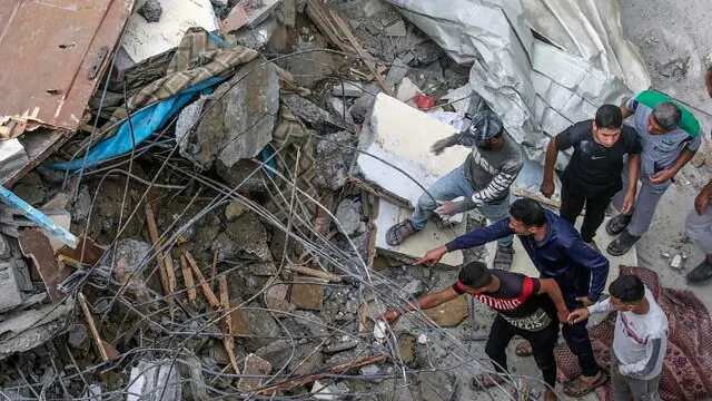 epa11338863 Palestinians search for missing people under the rubble of a destroyed building following an Israeli air strike in Al Nuseirat refugee camp, central Gaza Strip, 14 May 2024. According to the Palestinian Civil Defence, more than 18 Palestinians were killed in an overnight Israeli air strike in Al Nuseirat camp, with a dozen more missing under the rubble of a destroyed building. More than 35,000 Palestinians and over 1,455 Israelis have been killed, according to the Palestinian Health Ministry and the Israel Defense Forces (IDF), since Hamas militants launched an attack against Israel from the Gaza Strip on 07 October 2023, and the Israeli operations in Gaza and the West Bank which followed it. EPA/MOHAMMED SABER