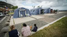 epa11357629 People walk in a tent city, in Naples, Italy, 21 may 2024. Hundreds of citizens of Pozzuoli, Naples were evacuated and spent the night in the two small tent cities set up by the Civil Protection in the port area and in the Pertini seafront area, due to the seismic swarm in the Campi Flegrei area that recorded approximately 150 earthquakes, the strongest of which was magnitude 4.4, within the Solfatara. EPA/CESARE ABBATE