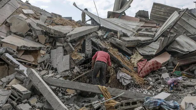 epa11338847 Palestinians search for missing people under the rubble of a destroyed building following an Israeli air strike in Al Nuseirat refugee camp, central Gaza Strip, 14 May 2024. According to the Palestinian Civil Defence, more than 18 Palestinians were killed in an overnight Israeli air strike in Al Nuseirat camp, with a dozen more missing under the rubble of a destroyed building. More than 35,000 Palestinians and over 1,455 Israelis have been killed, according to the Palestinian Health Ministry and the Israel Defense Forces (IDF), since Hamas militants launched an attack against Israel from the Gaza Strip on 07 October 2023, and the Israeli operations in Gaza and the West Bank which followed it. EPA/MOHAMMED SABER