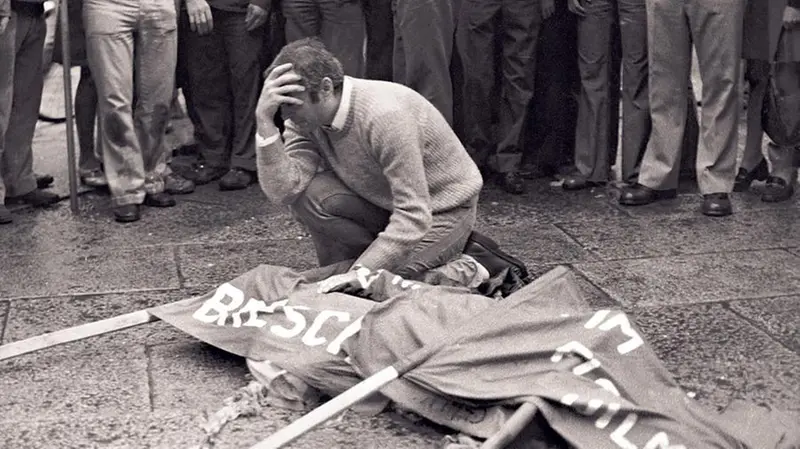 Arnaldo Trebeschi disperato vicino al corpo del fratello Alberto, ucciso dalla bomba in piazza della Loggia