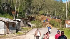 epa11365143 People walk with their belongings in the area where a landslide hit the village of Kaokalam, Enga province, Papua New Guinea, 24 May 2024. A landslide reportedly killed about 100 people in a remote village of northern Papua New Guinea. EPA/NINGA ROLE BEST QUALITY AVAILABLE AUSTRALIA AND NEW ZEALAND OUT EDITORIAL USE ONLY EDITORIAL USE ONLY